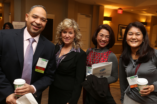 Photo of Four Smiling Conference Attendees 